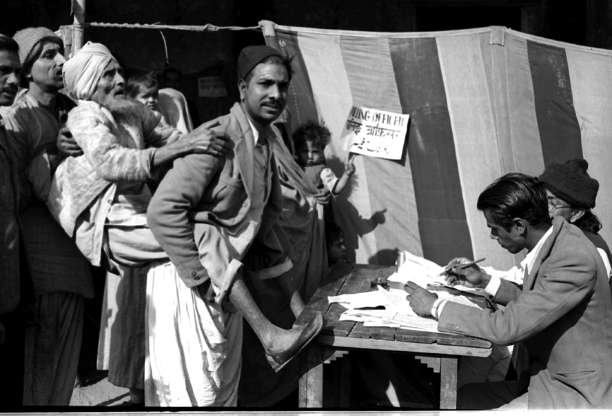 First General Election in India: A blind old man being carried towards a polling booth by his son, to help him to cast his vote, near a polling station in Jama Masjid area in Delhi. (Source: Photodivision.gov.in)