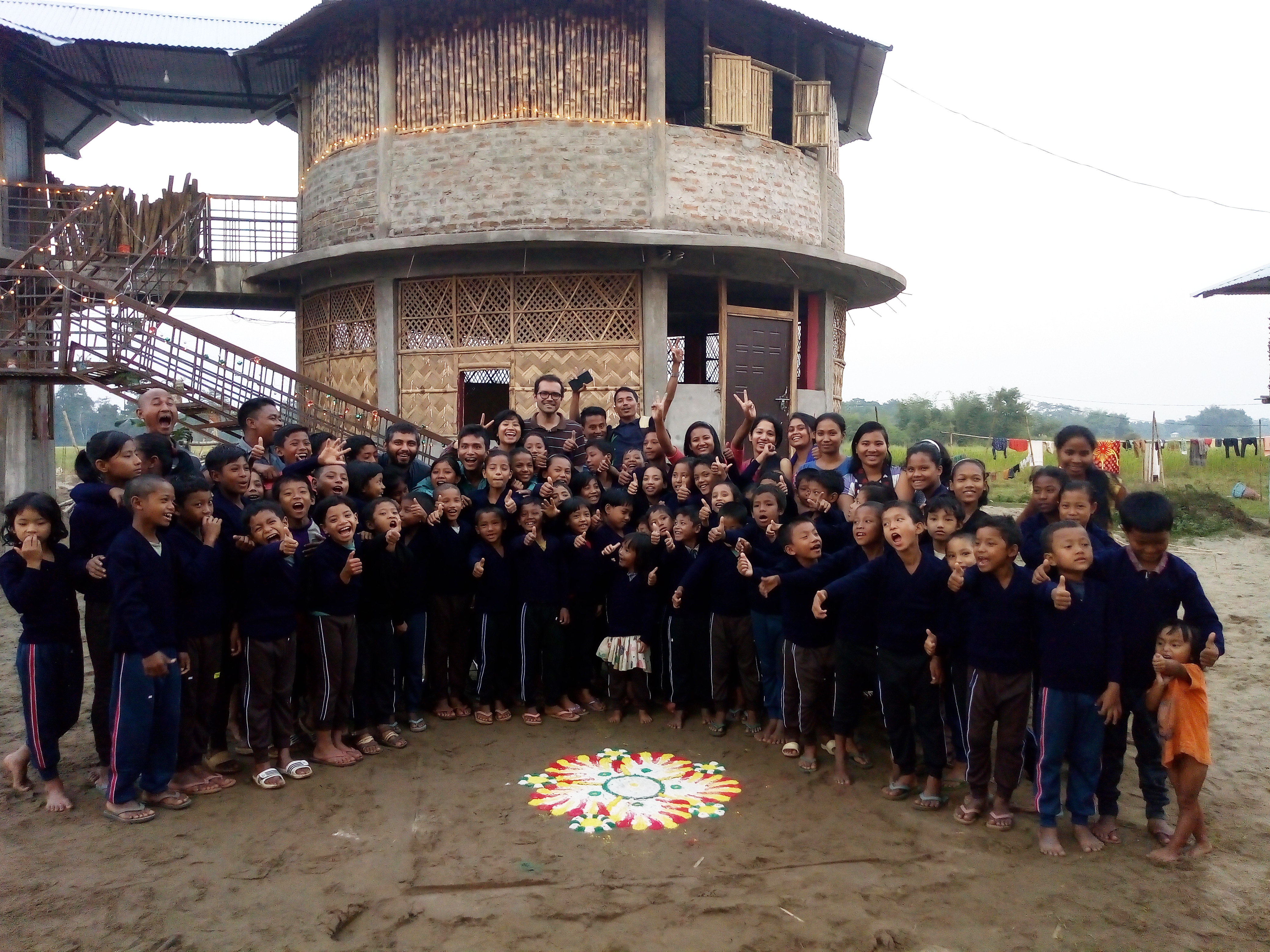 In the background, school structures built using traditional Mising techniques.
